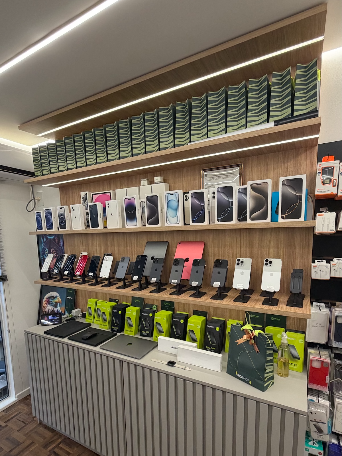 Interior da loja NG SHOP em Joinville, com prateleiras de iPhones, iPads e acessórios Apple
